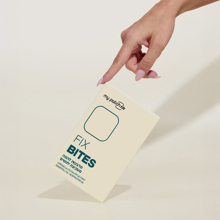 יד מצביעה על קופסה בצבע קרם שעליה כתוב "FIX BITES", מדבקות להגנה מעקיצות יתושים.