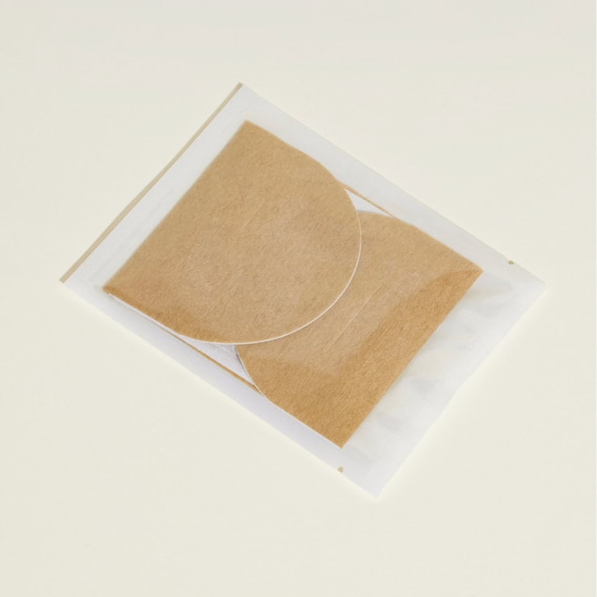 שני רפידות חצי עיגוליות בצבע חום בהיר, בתוך אריזה שקופה על רקע בהיר.