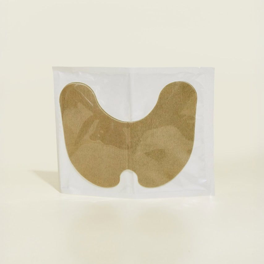 בתמונה, מדבקת בד חומה בצורת האות "U" הפוכה, ארוזה בשקית ניילון שקופה.