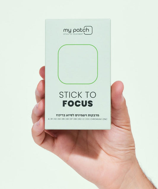 יד מחזיקה קופסה לבנה של מדבקות ויטמינים בשם "Stick to Focus" לסיוע בריכוז.