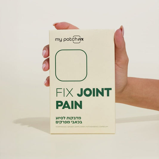 יד אוחזת קופסה בצבע קרם של מדבקות "FIX JOINT PAIN" (מדבקות לסיוע בכאבי מפרקים).
