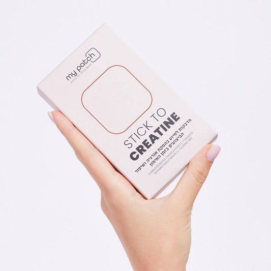 יד אוחזת קופסה בצבע קרם עם הכיתוב "STICK TO CREATINE" ומדבקה מלבנית.